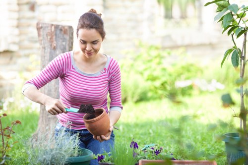 Professional gardener tending to plants in a well-maintained garden